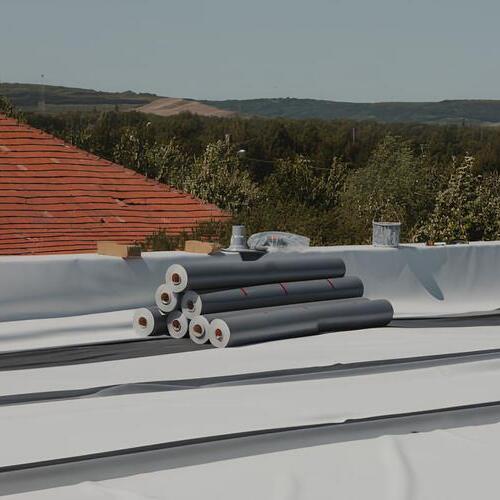 rolls of PVC roofing on a rooftop