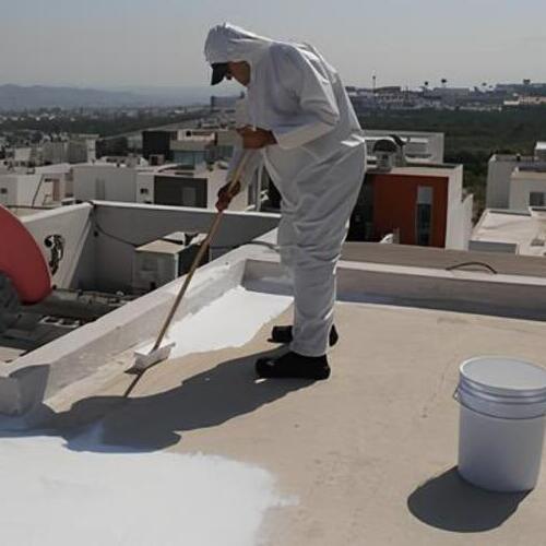 a worker laying down an elastomeric roof coating