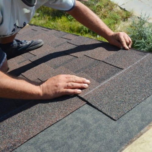 a worker patching a shingle roof